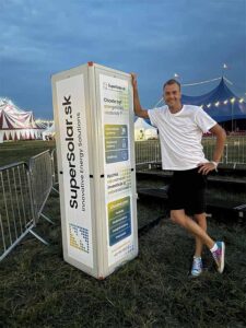 Man standing beside Supersolar.sk display at festival